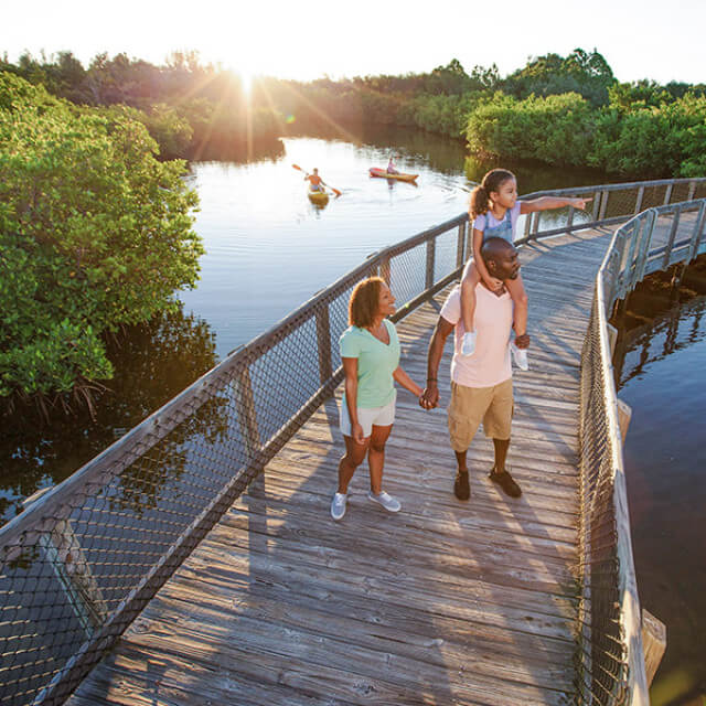 A family enjoys sunset views of Emerson Point Preserve in Bradenton, Florida