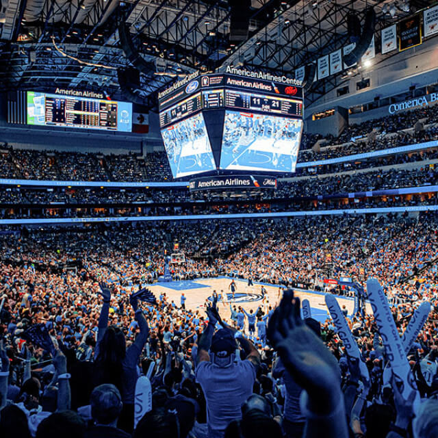 Fans watch a basketball game at the American Airlines Center in Dallas, Texas