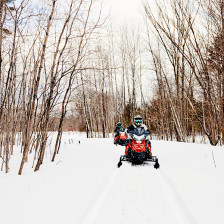Snowmobiling on wooded trails in Bethel, Maine