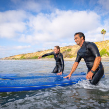 A couple surfs at Ponto Beach in Carlsbad, California